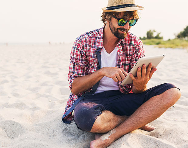 Man at the beach using a tablet